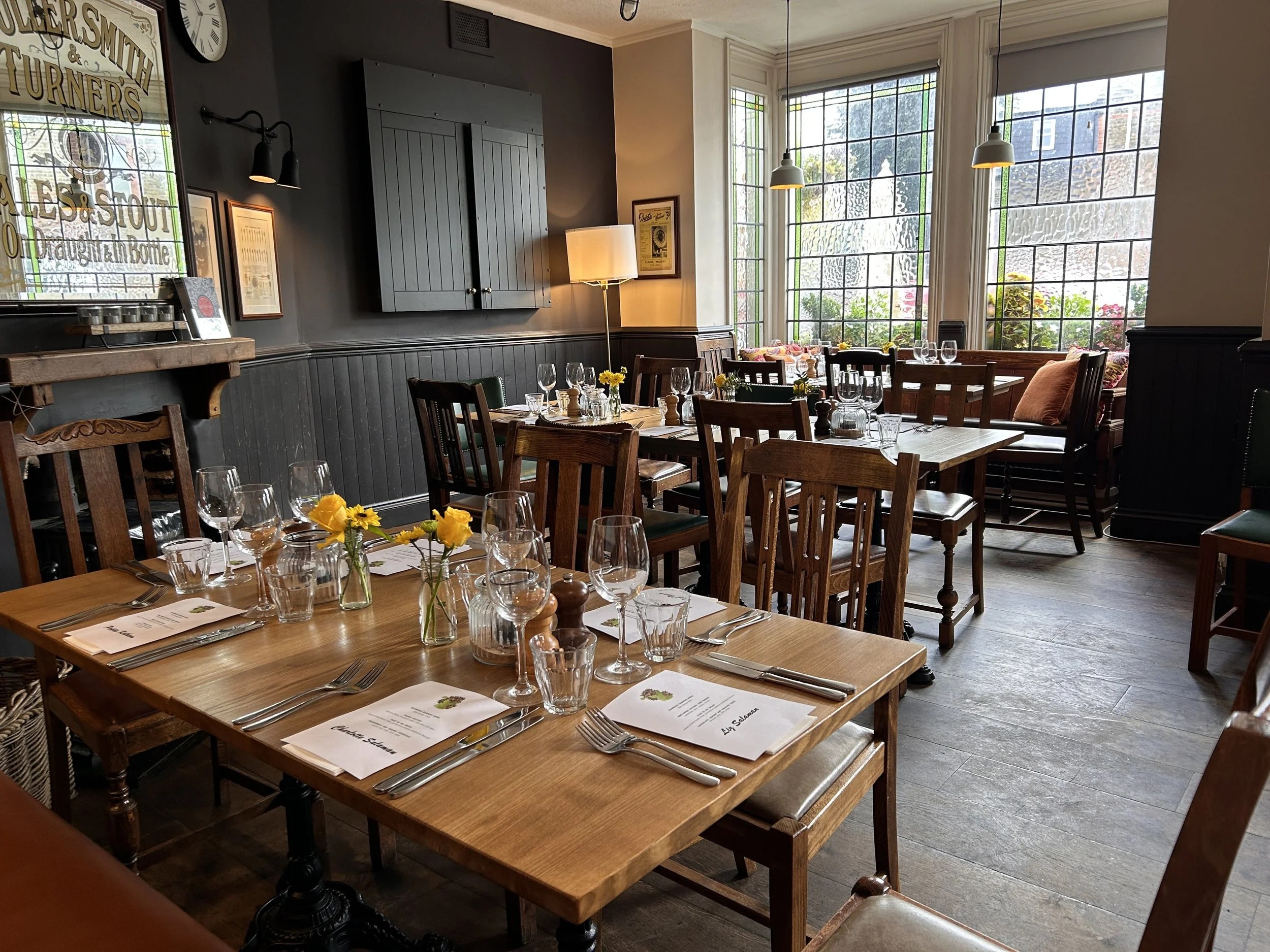 The dining room laid for service, with Fuller's mirror and stained glass