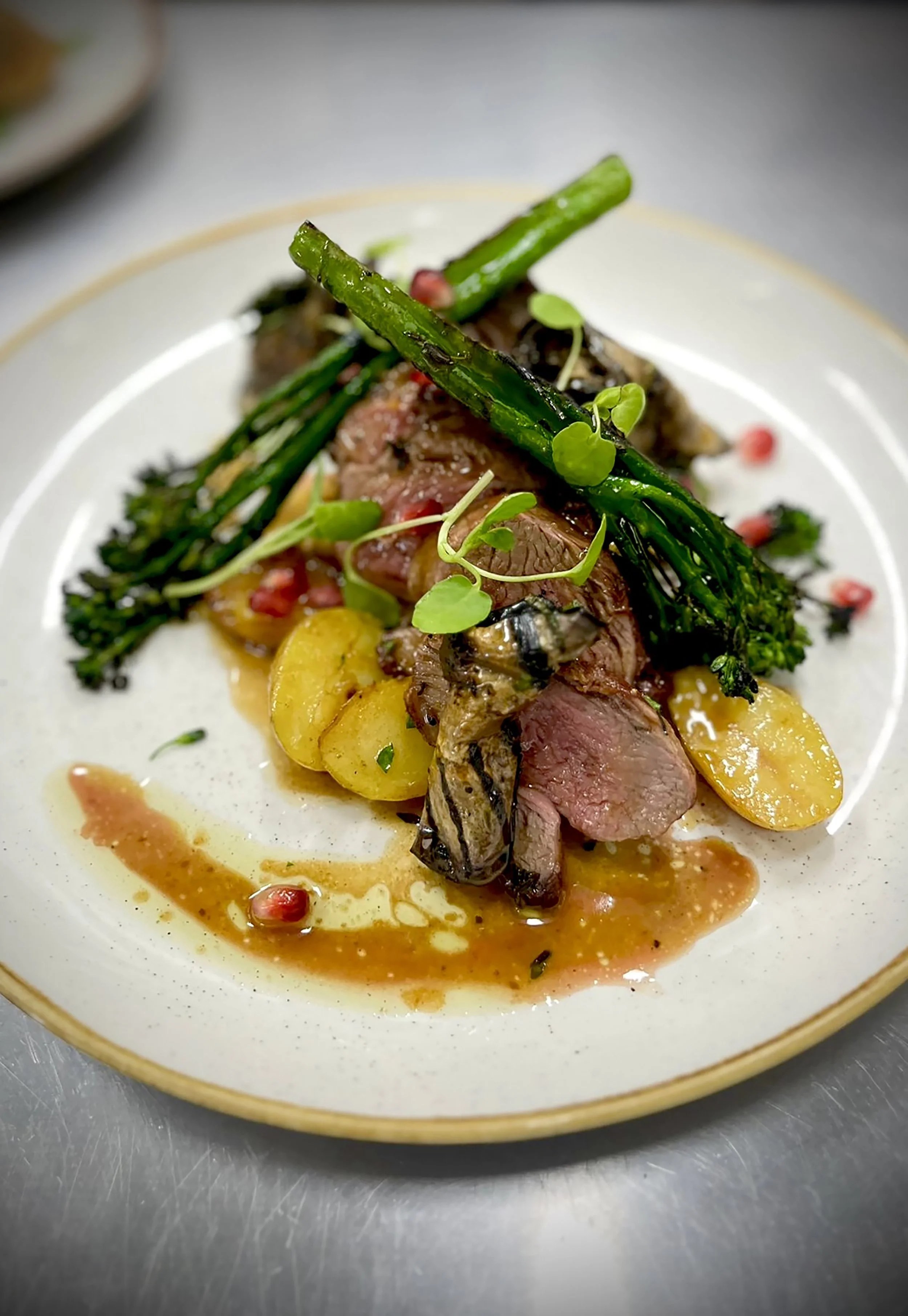 Sliced lamb with broccolini, potatoes and a glossy sauce