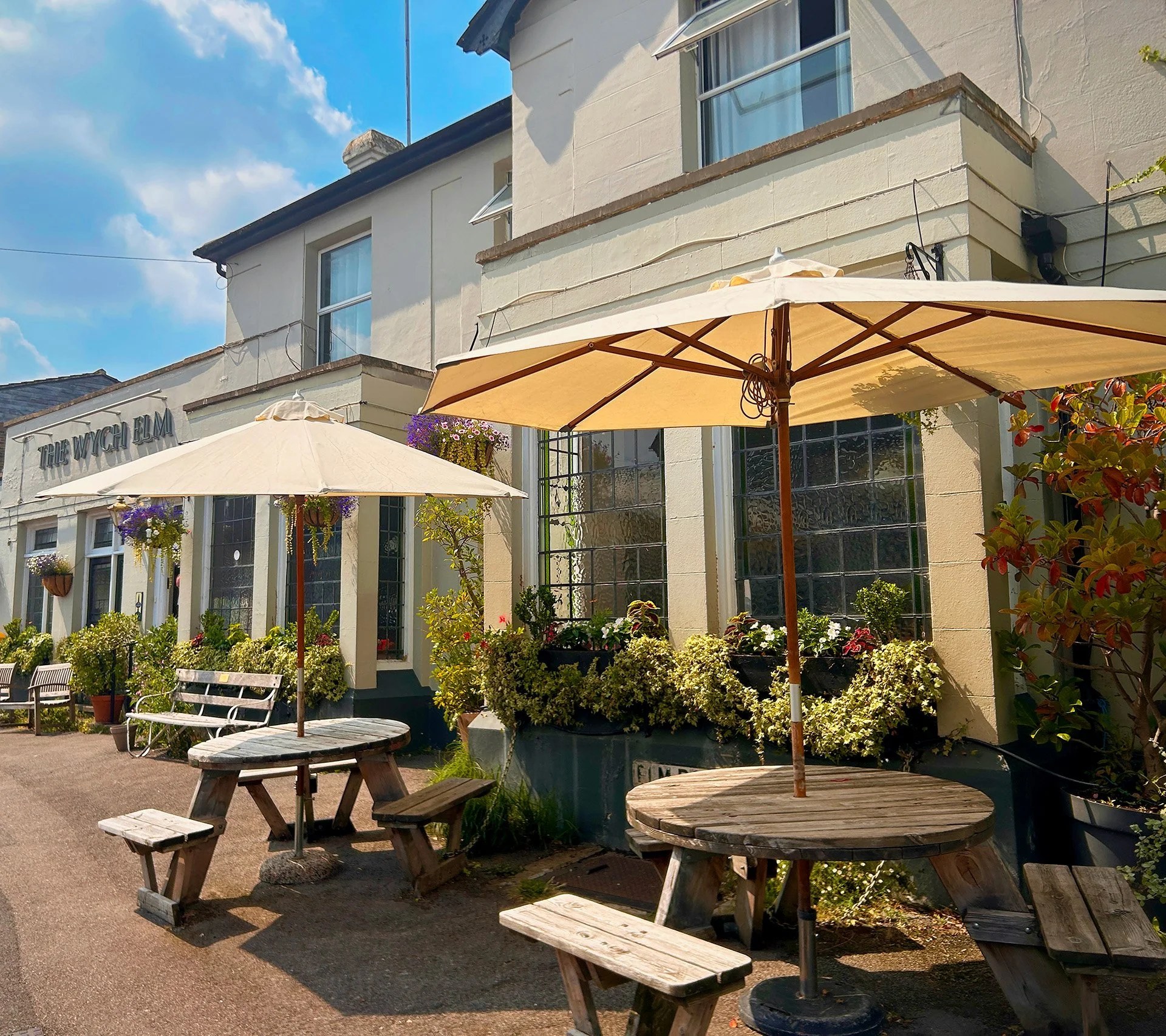 Picnic tables and cream parasols outside the pub